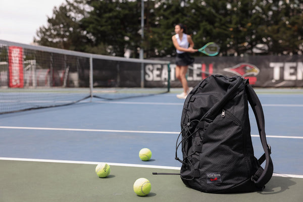 A Smart Alec 2.0 in the foreground while a person plays tennis in the background.